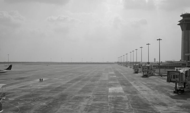 Airport tarmac with jet bridges and an air traffic control tower