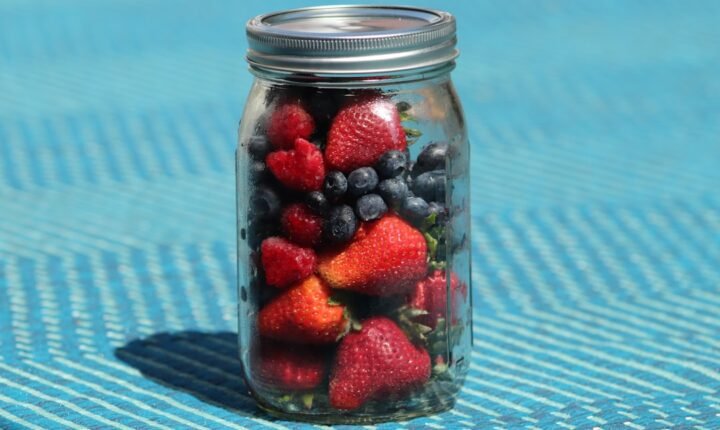 Jar of overnight oats layered with strawberries, blueberries and raspberries