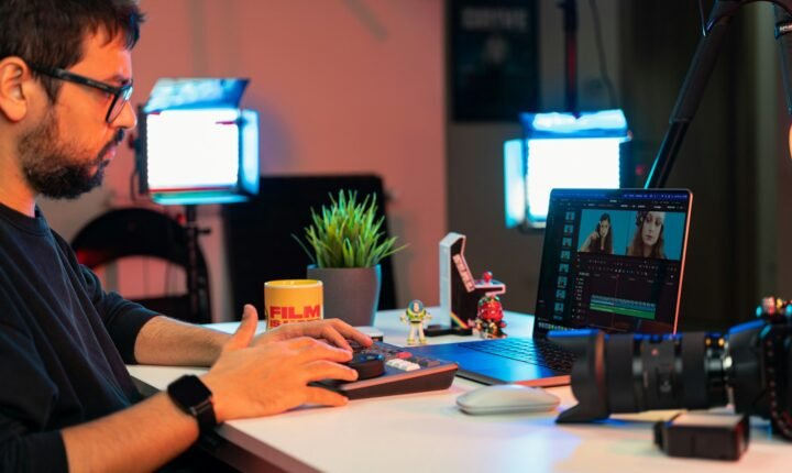 Filmmaker editing video on a laptop at a desk, illustrating creator workflows discussed in YouTube Studio's 2026 update