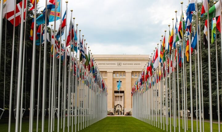 International flags outside a conference venue, illustrating diplomatic talks on AI safety