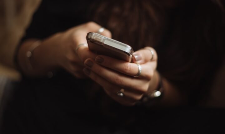 Young person using a smartphone, illustrating Australia's under-16 social media account rules