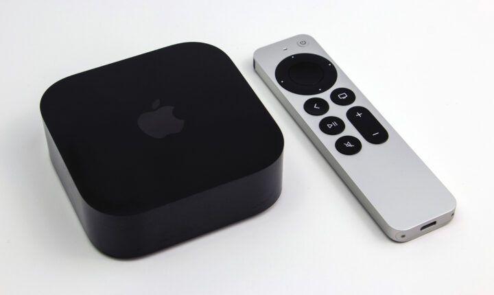 Apple TV 4K third-generation box beside its Siri Remote on a wooden surface