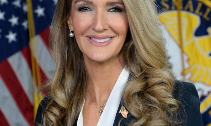 Official portrait of SBA Administrator Kelly Loeffler in front of United States flags, February 19, 2025