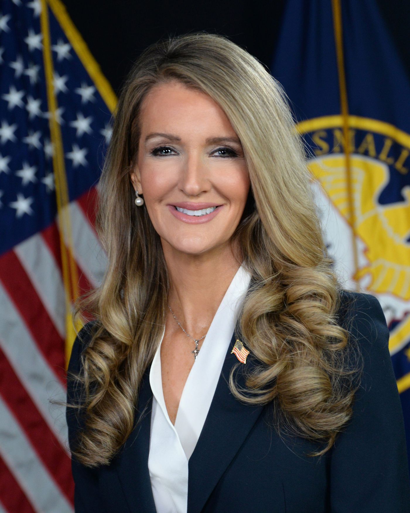 Official portrait of SBA Administrator Kelly Loeffler in front of United States flags, February 19, 2025