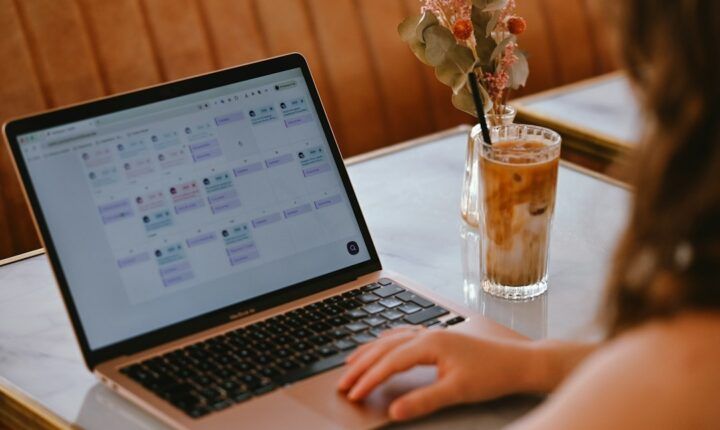 A person using a laptop with a calendar interface while planning work