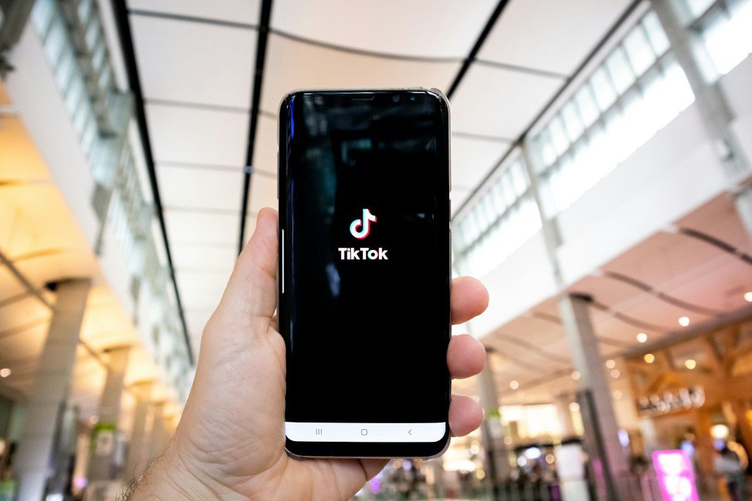 Person holding a smartphone with the TikTok app open inside a shopping mall