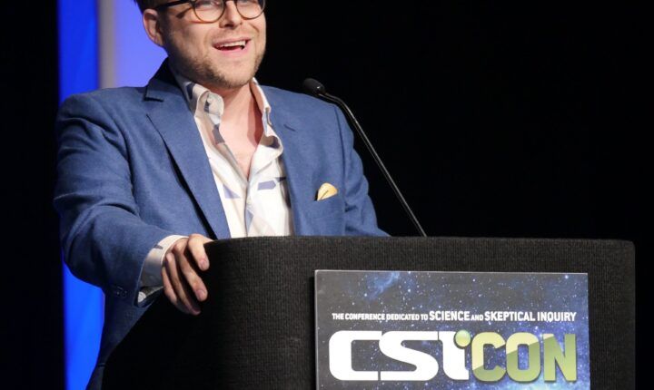 Adam Conover speaking at CSICon 2018, the YouTube critic in this story