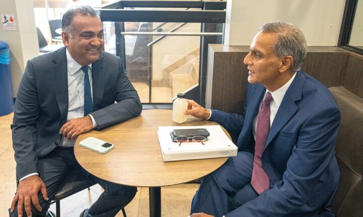YouTube CEO Neal Mohan, left, smiling at a cafe table during a meeting in New York in September 2023
