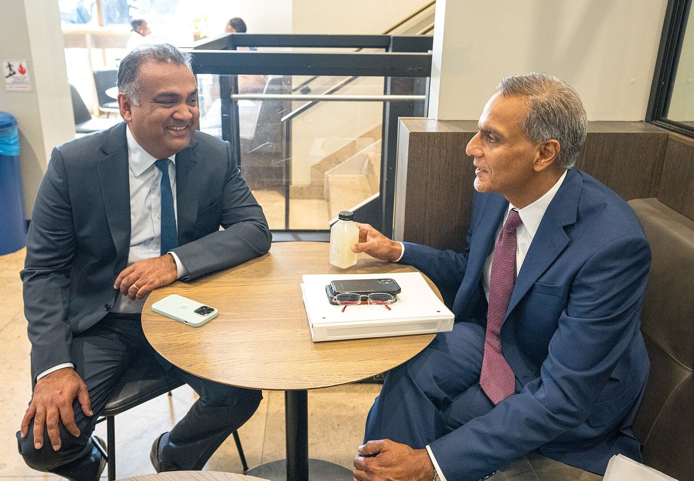 YouTube CEO Neal Mohan, left, smiling at a cafe table during a meeting in New York in September 2023