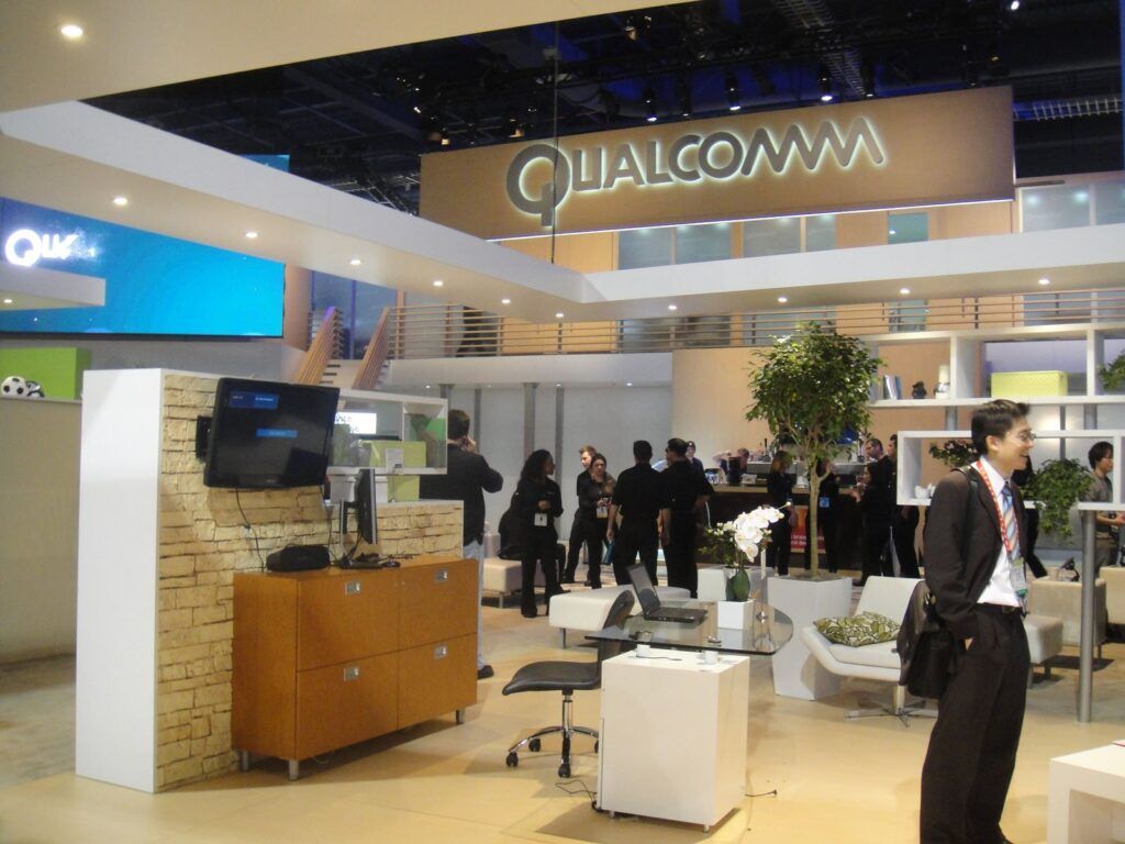 Qualcomm exhibition booth; the Qualcomm–Amazon AI chip deal is examined here